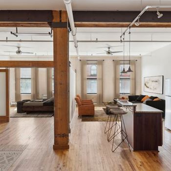 A living room with a brown floor and white walls.